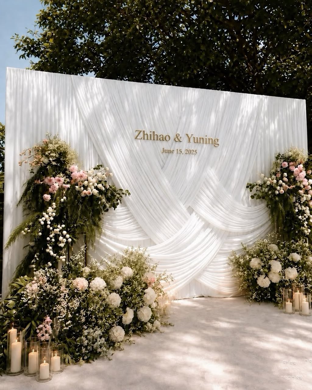 White draped wedding backdrop with blush roses and candles